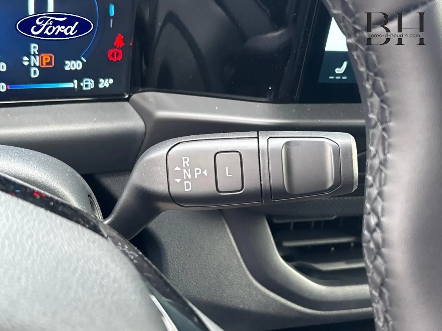 Gros plan sur la commande de boîte automatique à levier sur le côté droit du volant dans un Ford Transit Custom noir.