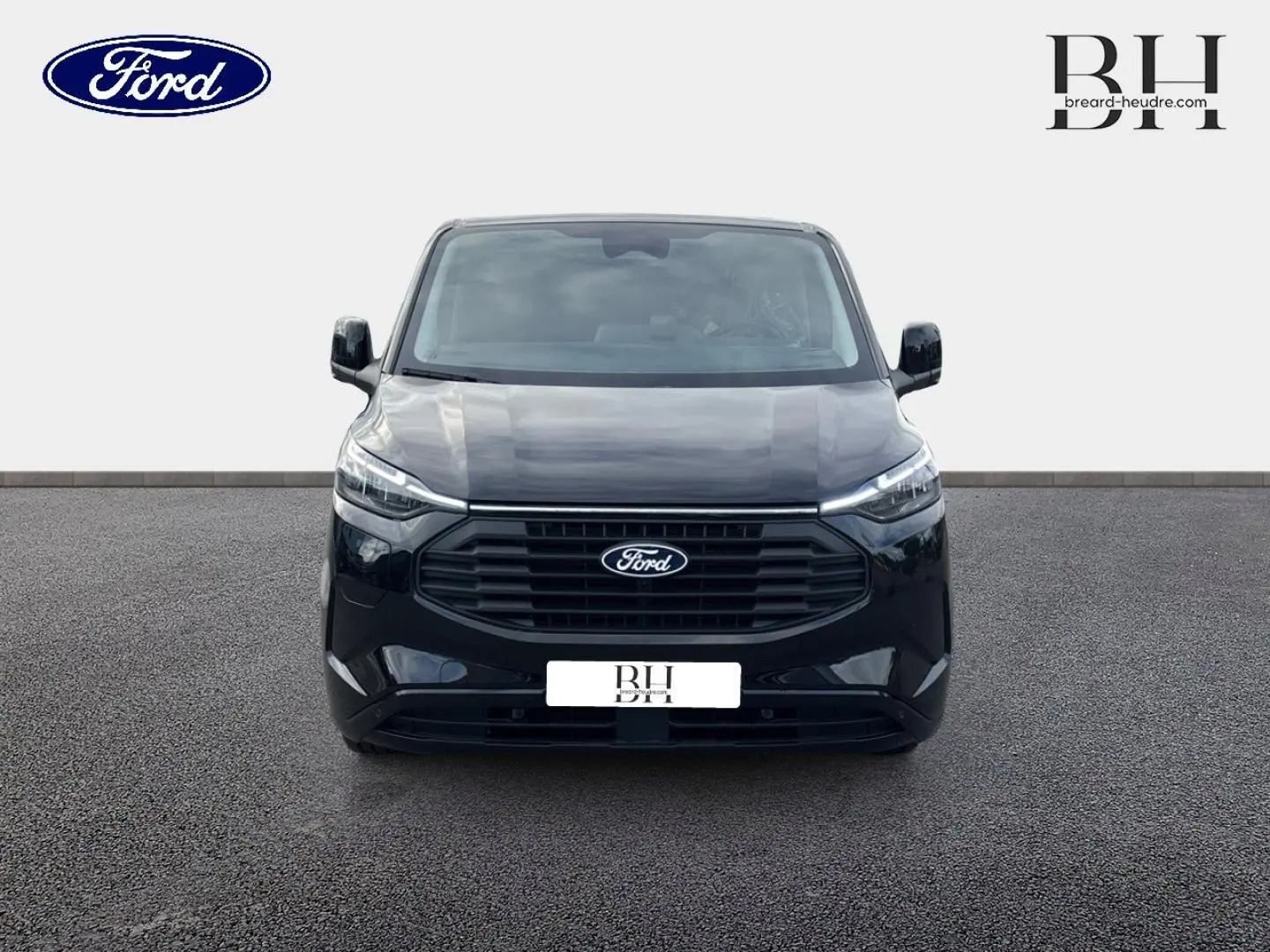 Vue frontale du Ford Transit Custom Fourgon noir Agate Métallisée avec calandre large et phares LED fins.