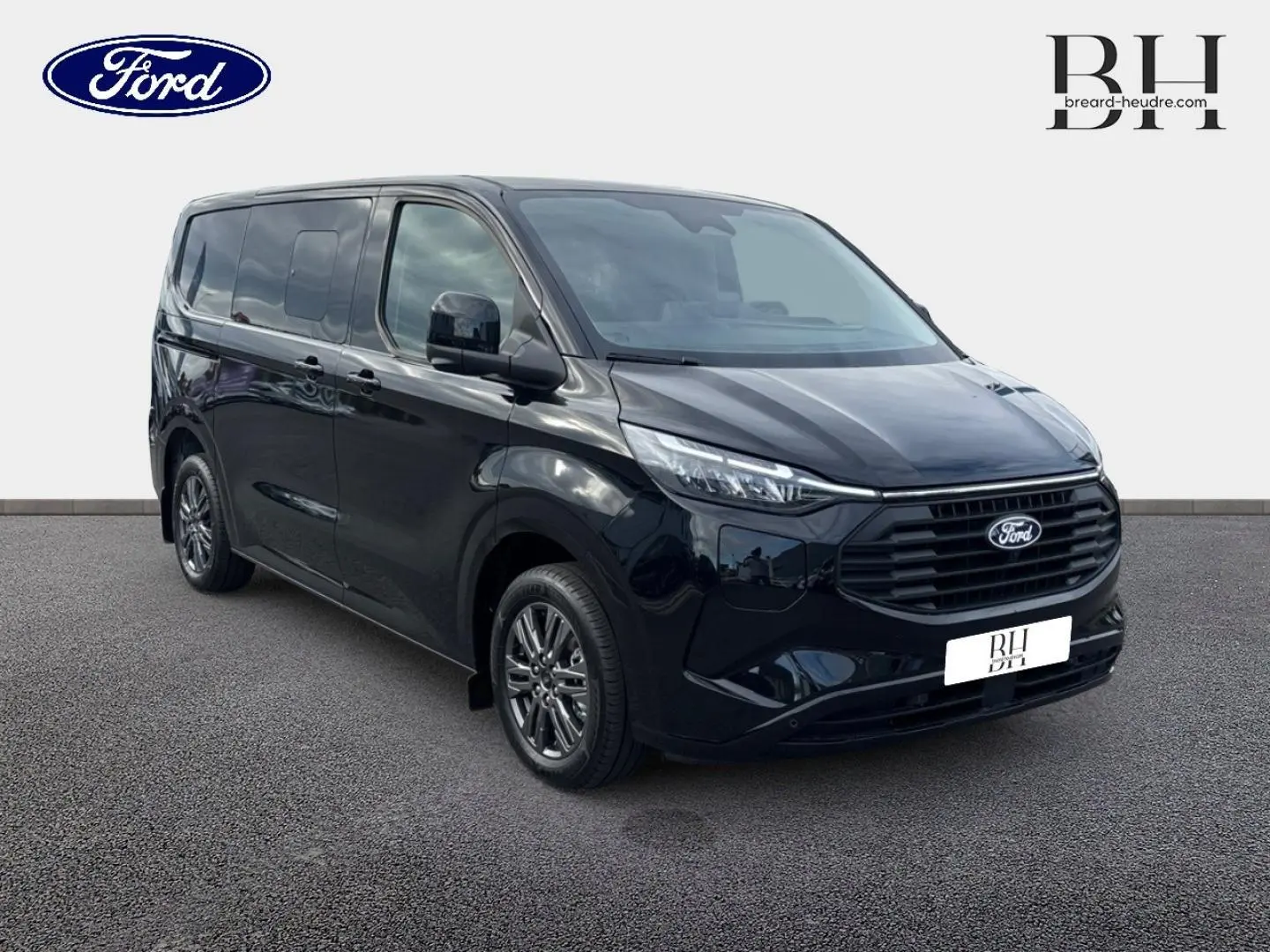 Ford Transit Custom Fourgon noir Agate métallisé vu en 3/4 avant droit avec jantes alu gris carbone et calandre noire.