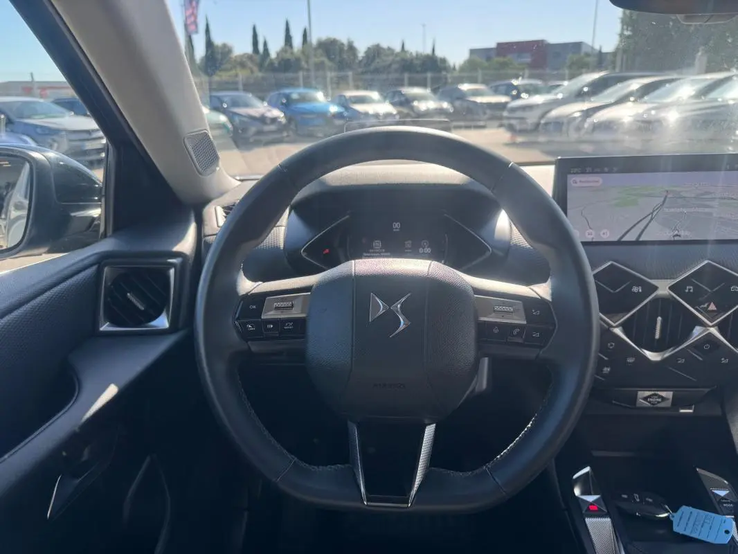 Vue intérieure centrée sur le volant DS d'une DS3 100 BVM6 Bastille, avec écran tactile et tableau de bord numérique.