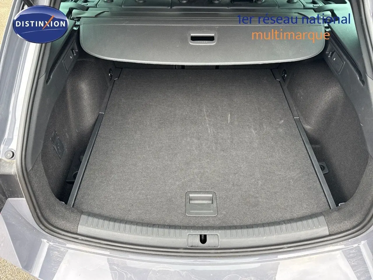 Coffre ouvert en vue arrière d'une CUPRA LEON ST 1.5 ETSI 150CH DSG gris Graphene, montrant l'espace de chargement vide.