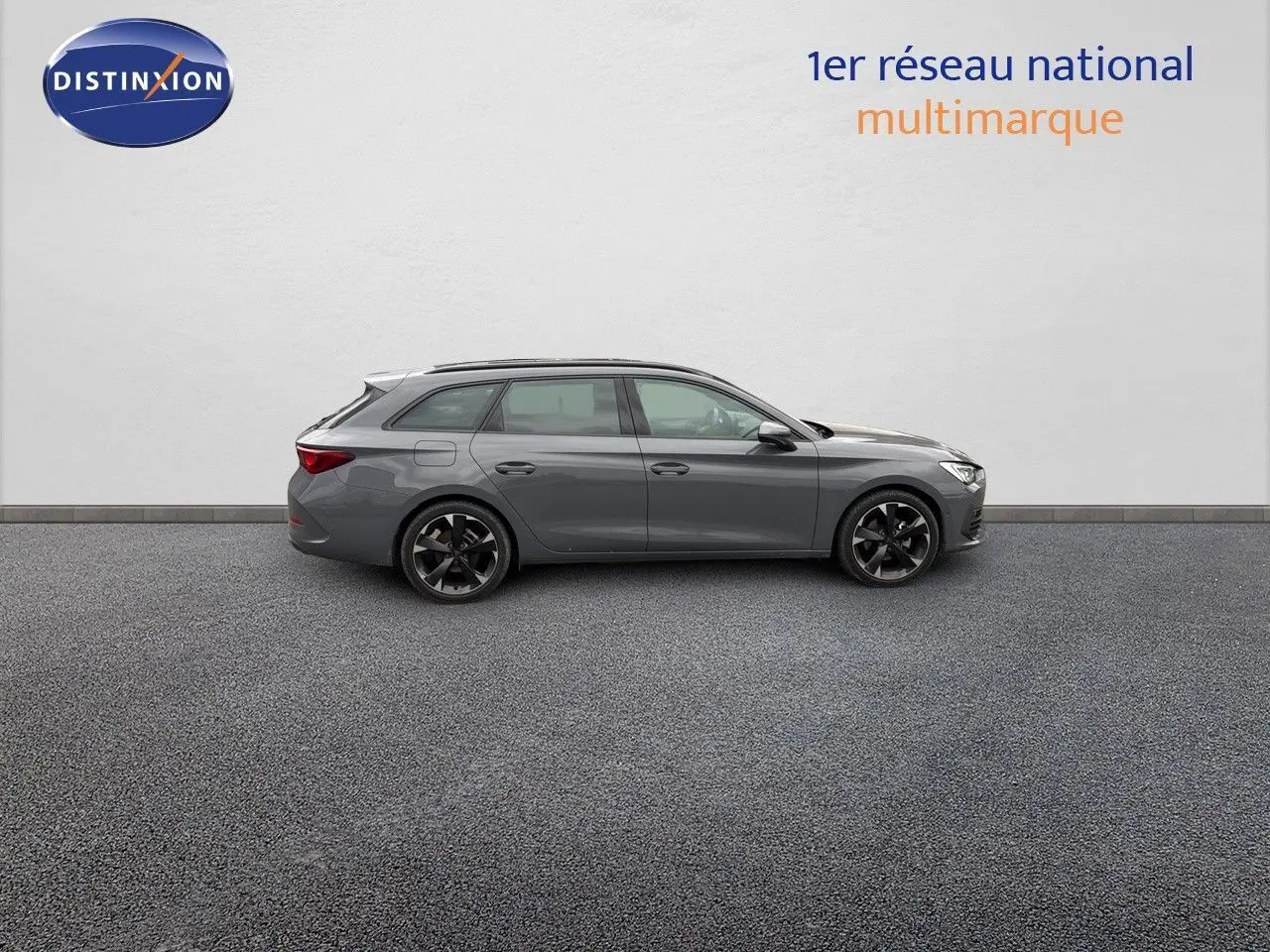 Profil latéral droit d'une CUPRA LEON ST 1.5 ETSI 150CH DSG gris Graphene, avec jantes noires et toit légèrement surélevé.