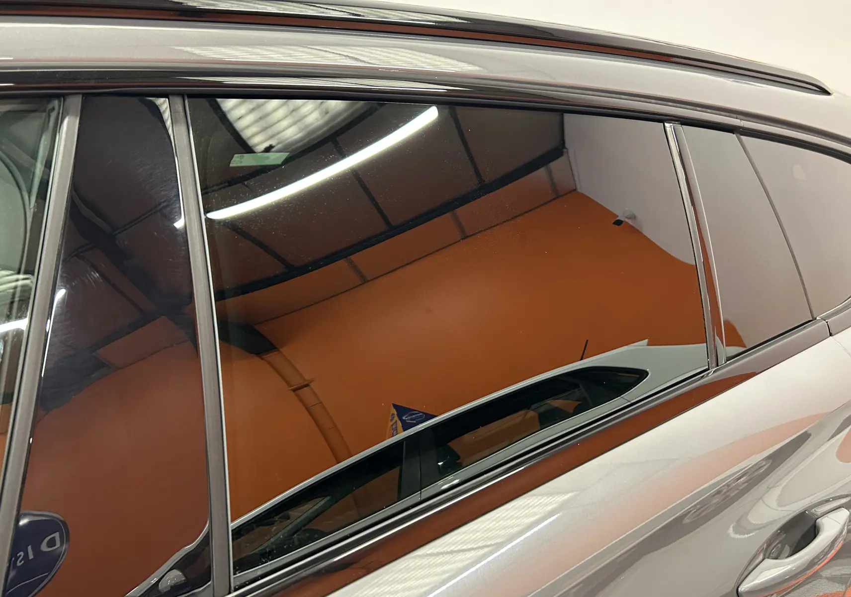 Reflet du côté gauche de la Peugeot 508 SW gris Selenium, mettant en valeur la ligne de toit et les vitres teintées.