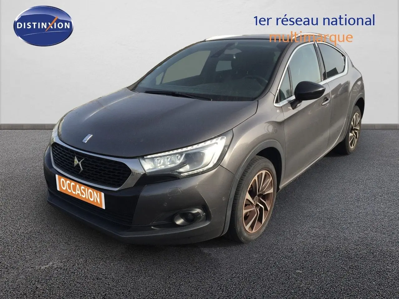Vue 3/4 avant droit d'une DS4 CROSSBACK gris platinium métal avec jantes bi-ton et calandre noire distinctive.