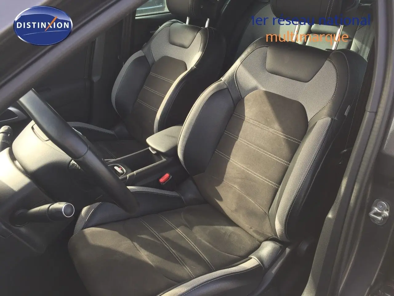 Vue intérieure côté conducteur du DS4 CROSSBACK 2017, sièges en cuir noir et tissu gris, volant et console visibles.