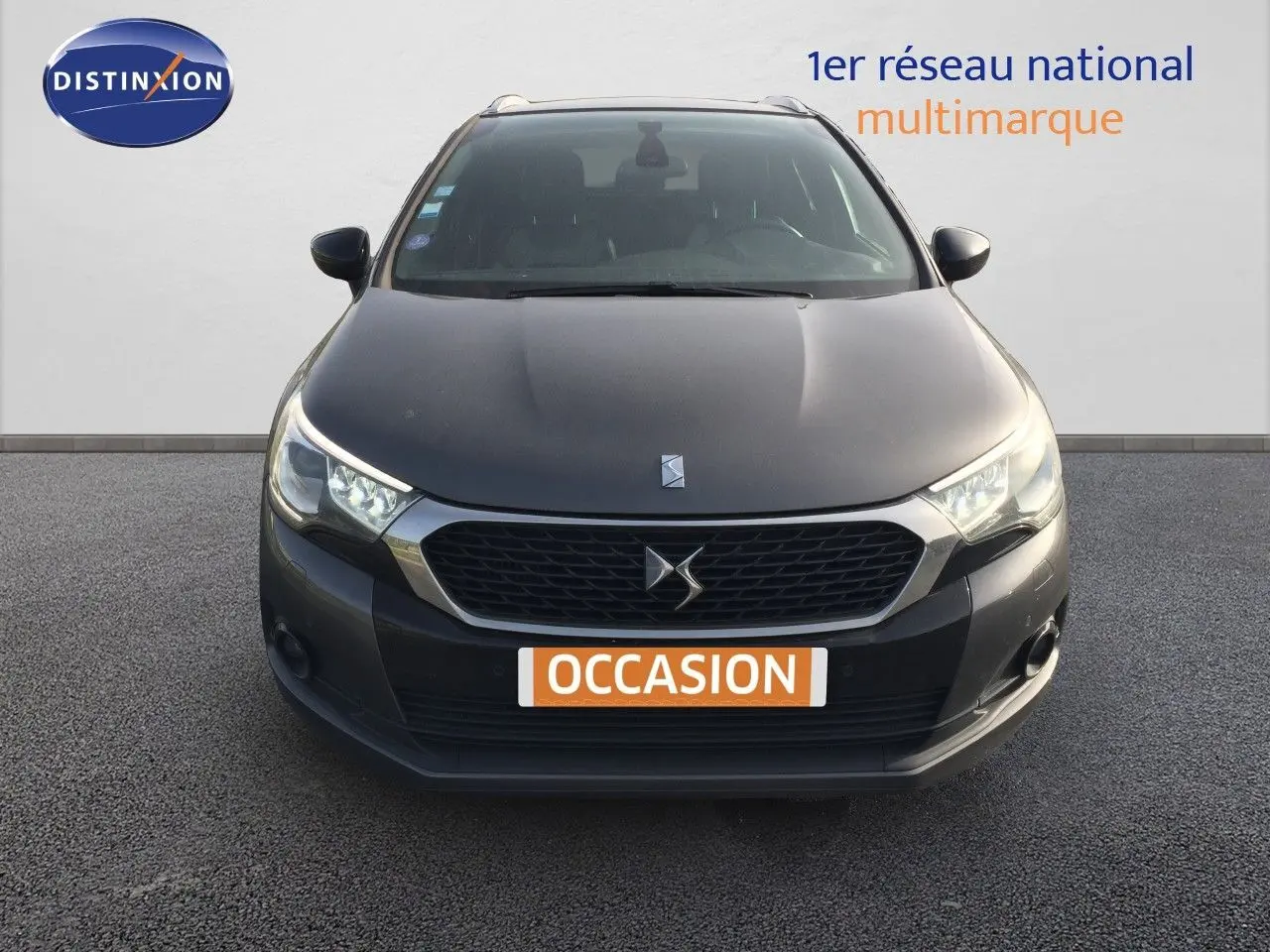 Vue frontale d'une DS4 CROSSBACK gris platinium métal avec calandre hexagonale et phares LED allumés.