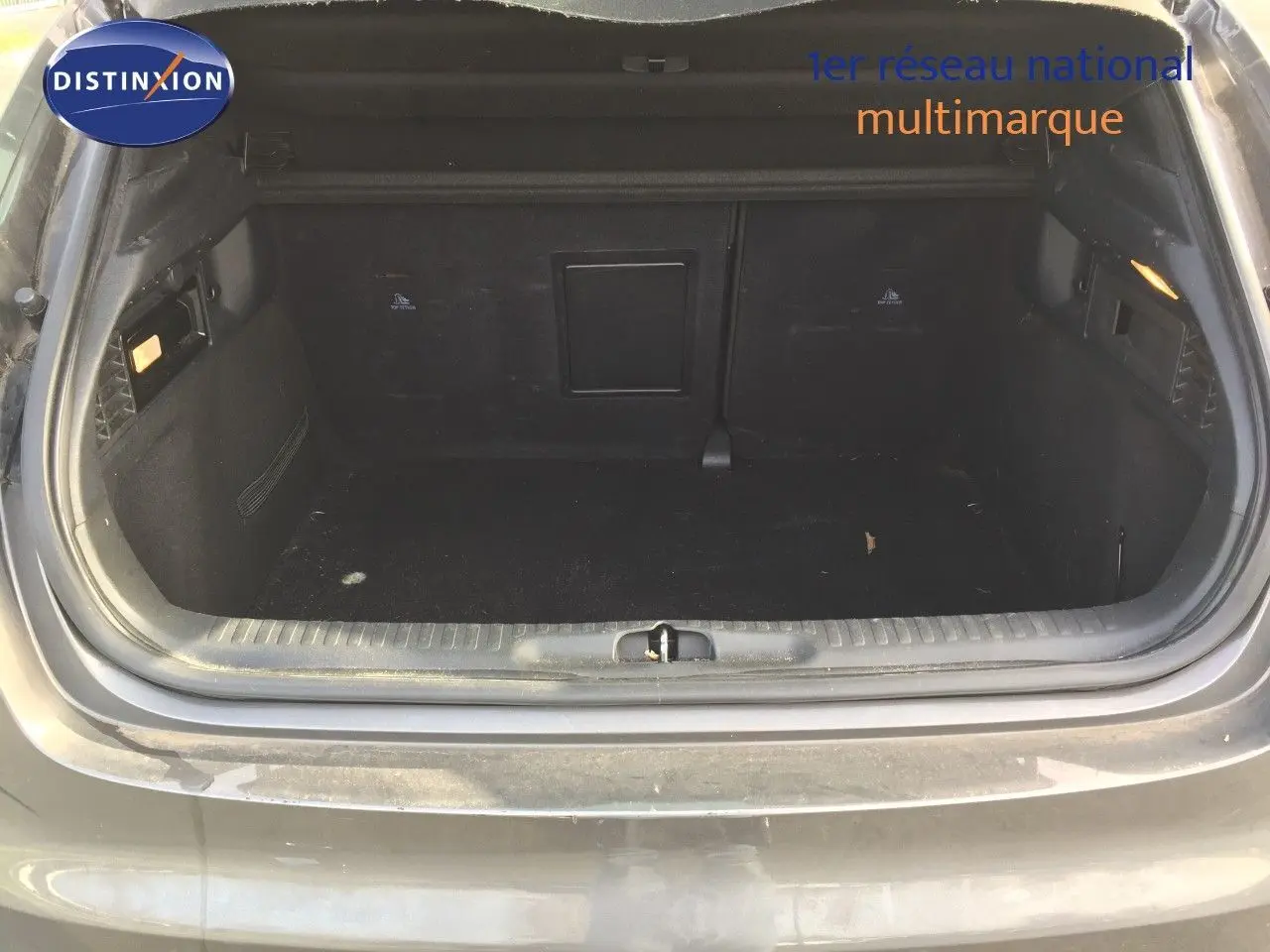 Coffre ouvert vu de l'arrière d'un DS4 CROSSBACK gris platinium métal, espace de chargement vide et propre.