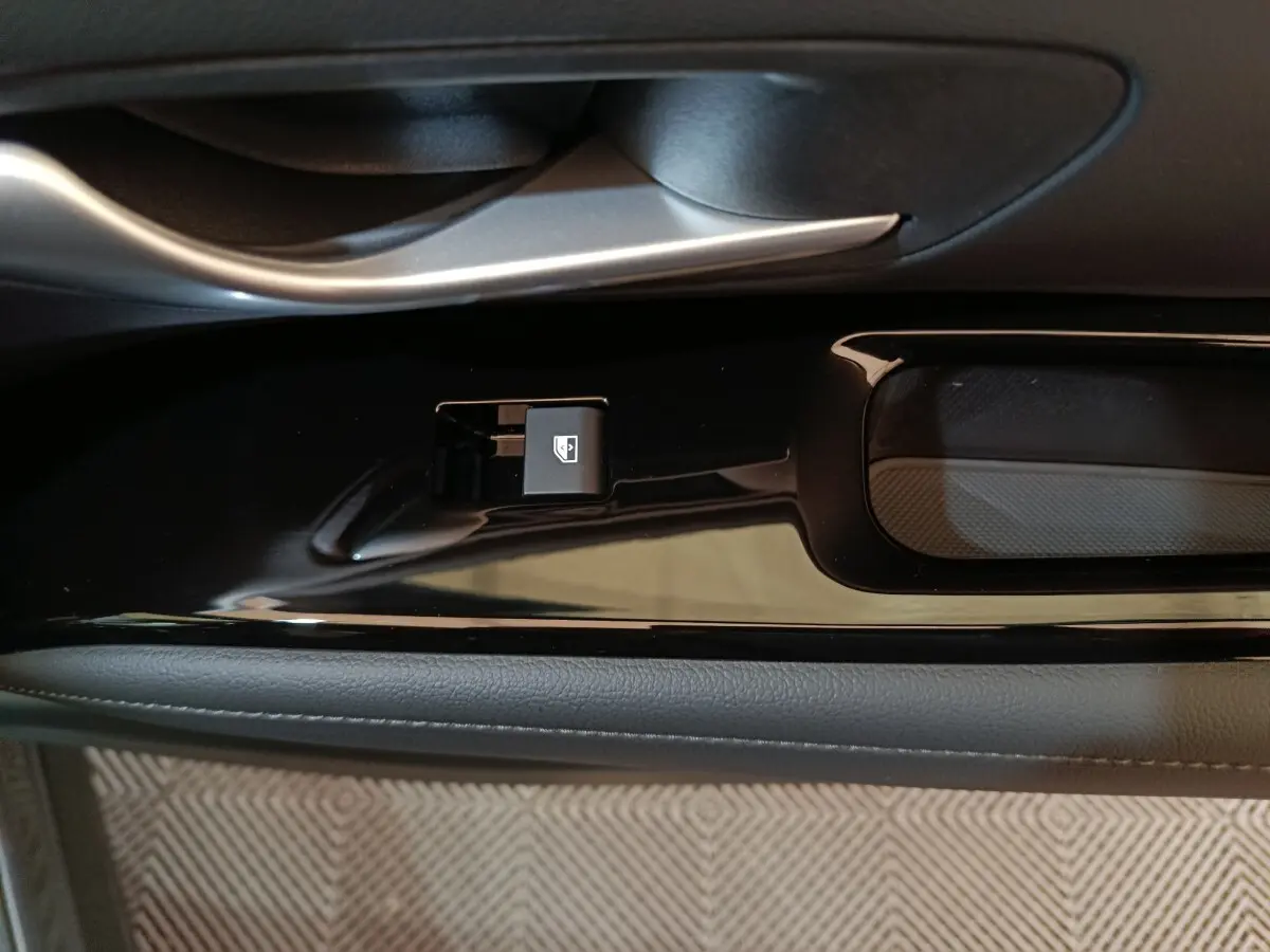 Gros plan sur la commande de lève-vitre côté conducteur du Hyundai Tucson gris clair 2025, finition Creative.