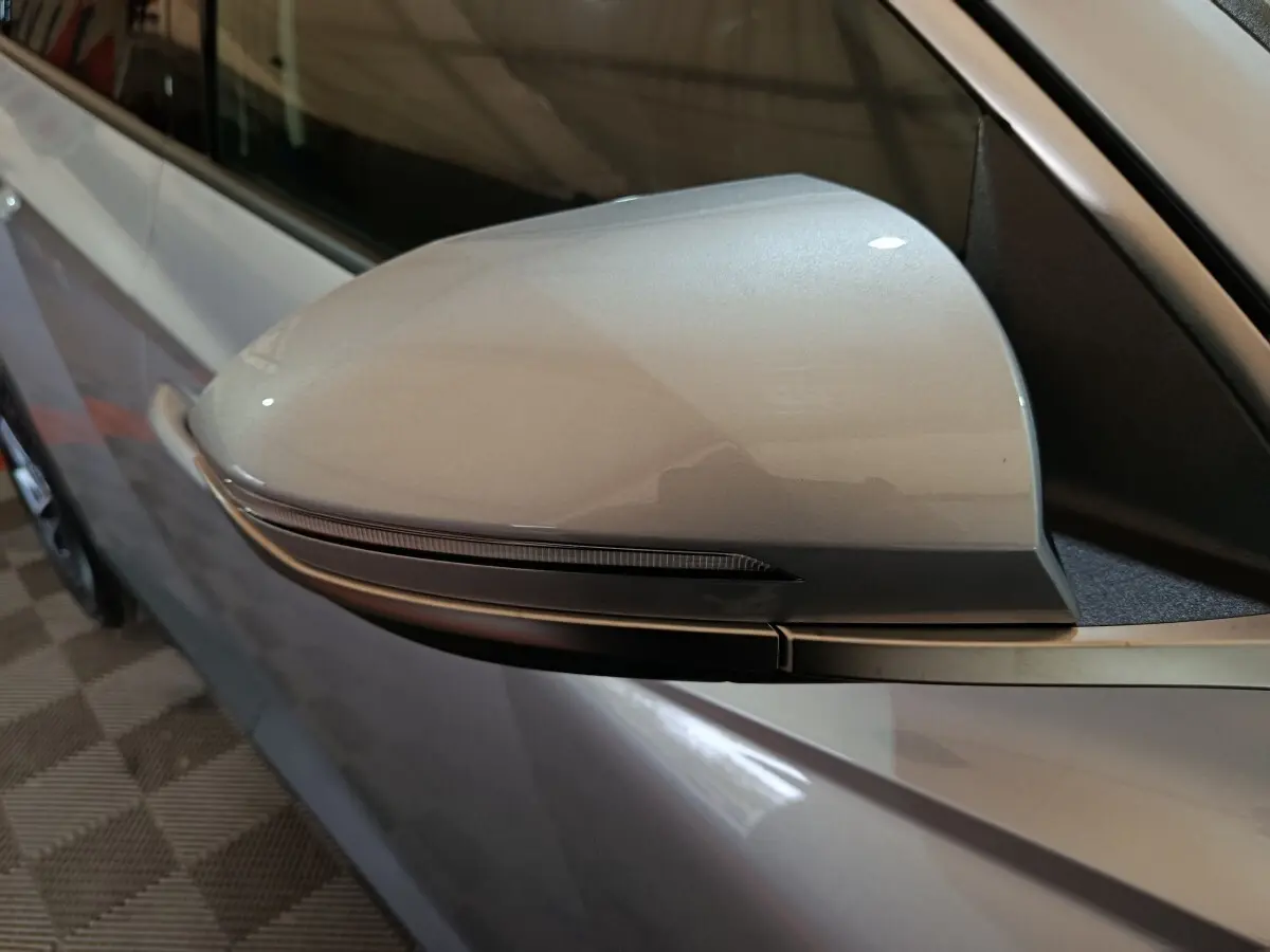 Rétroviseur côté conducteur gris clair du Hyundai Tucson 1.6 Hybrid 239 Creative Auto, avec clignotant intégré.