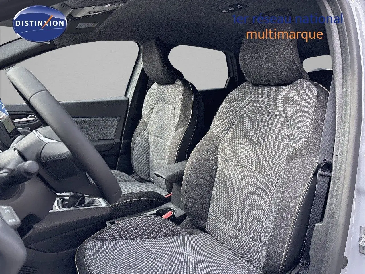 Vue intérieure côté conducteur du Renault Captur II gris Rafale, mettant en valeur les sièges tissu gris et l'habitacle moderne.