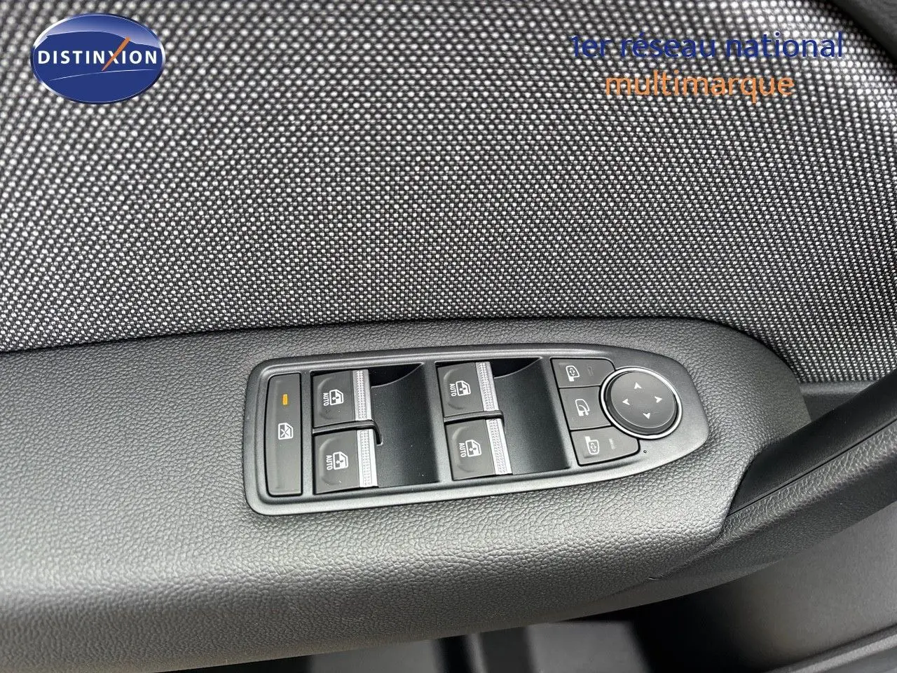 Gros plan sur les commandes de lève-vitres et rétroviseurs côté conducteur d’un Renault Captur gris Rafale 2025.