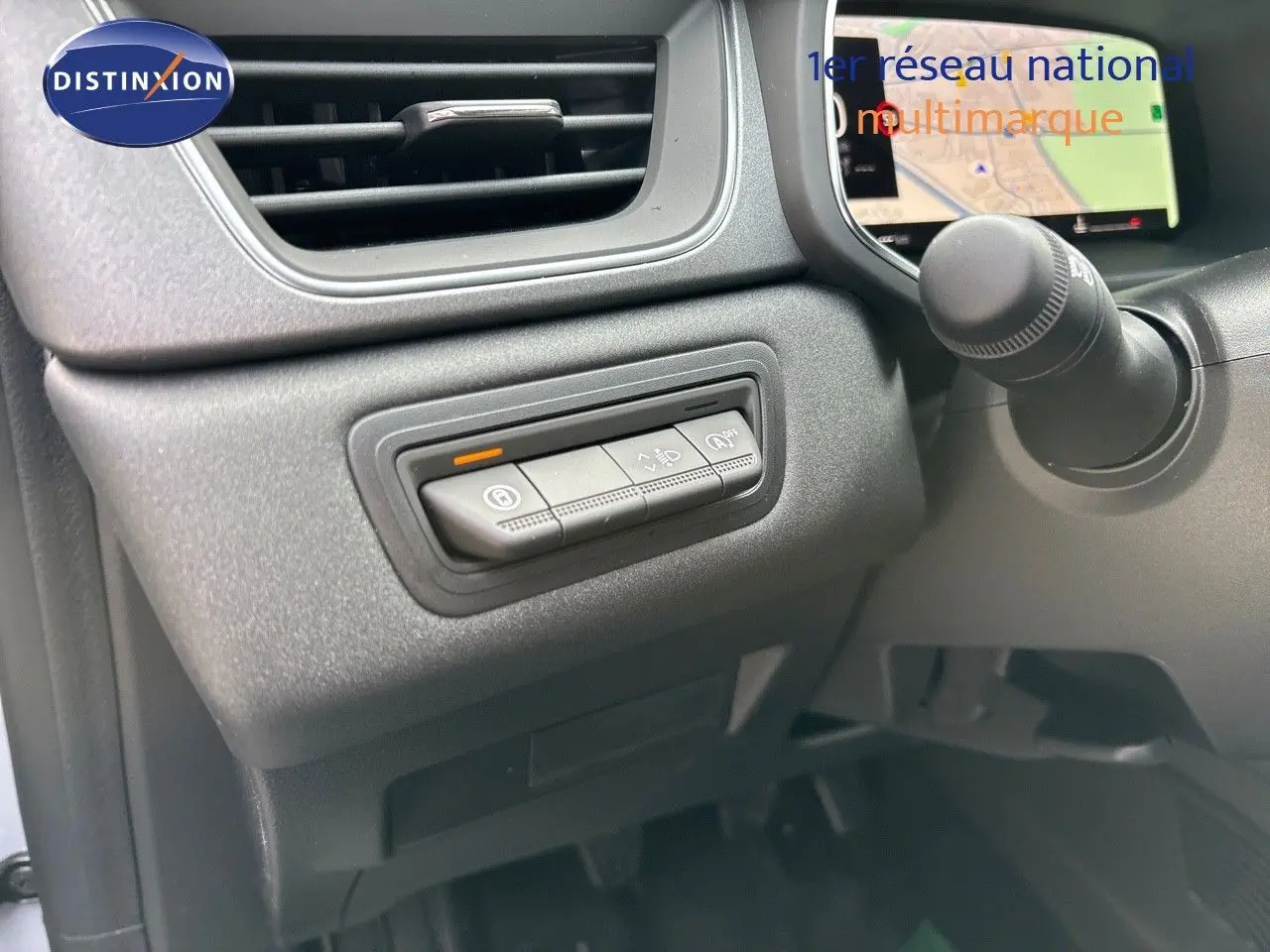 Vue intérieure côté conducteur du tableau de bord du Renault Captur gris Rafale, avec commandes d'assistance et écran de navigation.