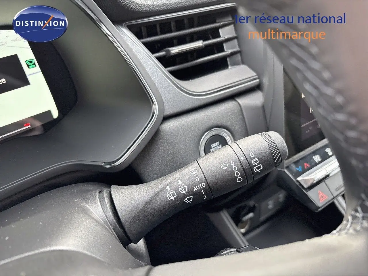 Gros plan sur la commande d'essuie-glace du Renault Captur II gris Rafale métal avec intérieur noir, bouton start visible.