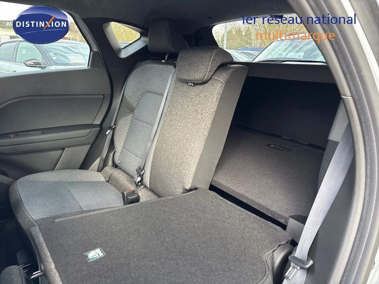 Vue intérieure arrière côté droit du Renault Captur II gris rafale métal, siège rabattable et banquette tissu gris.