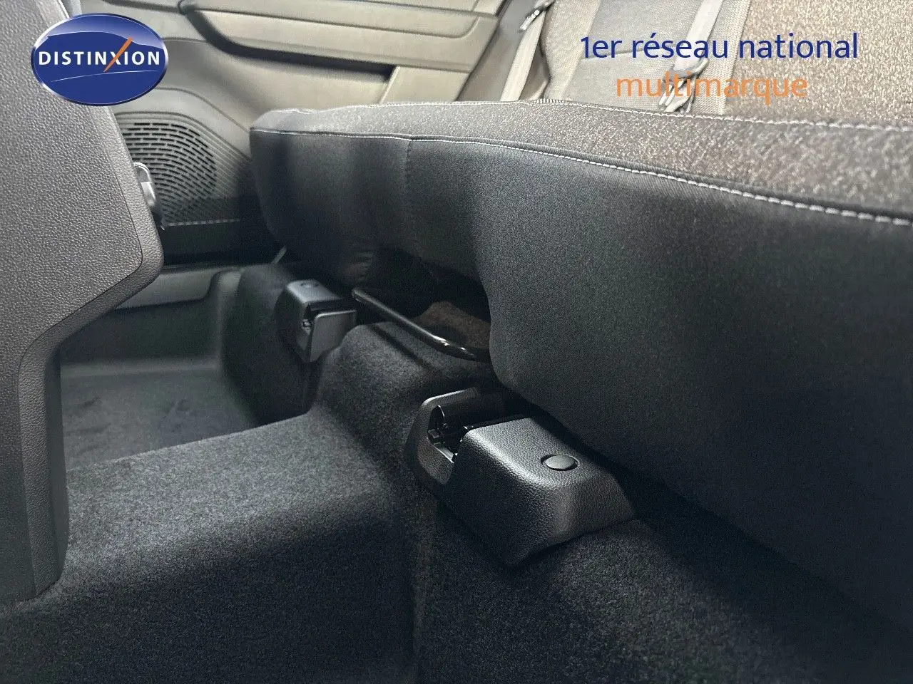 Détail intérieur montrant la fixation et la base du siège arrière en tissu gris noir du Renault Captur II hybride 2025.