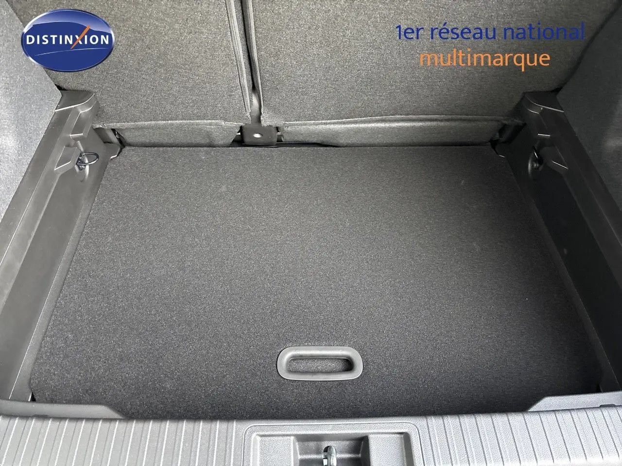 Vue plongeante sur le coffre spacieux et propre du Renault Captur II hybride 2025, avec revêtement noir uniforme.