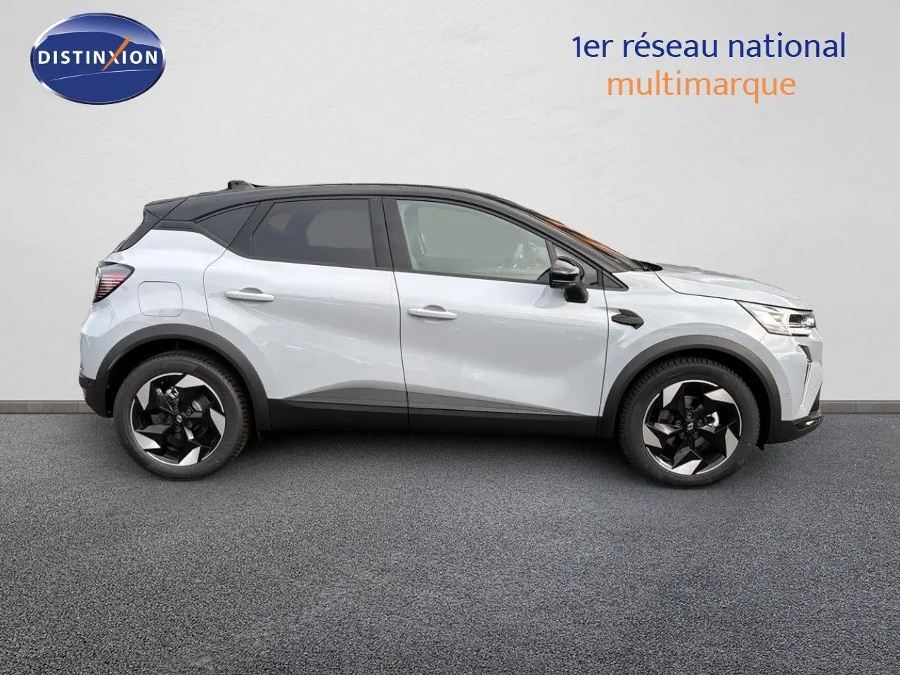 Profil côté droit du Renault Captur II hybride 2025 gris Rafale métal avec toit noir et jantes noires distinctives.