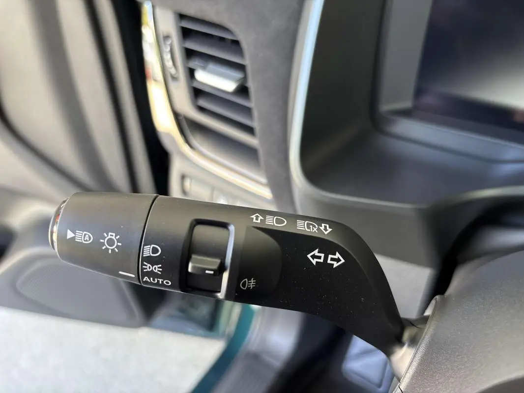 Gros plan sur la commande des feux et clignotants du Nissan Qashqai E-POWER 205 N-DESIGN, intérieur noir.