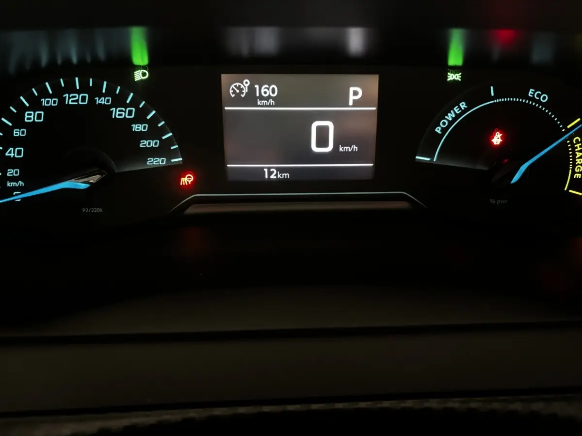Vue rapprochée du combiné d'instruments numérique de la Peugeot 208 Hybrid 110, affichant 0 km/h et 12 km au compteur.