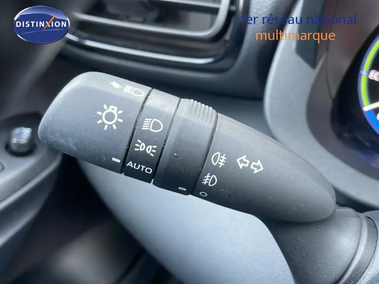 Gros plan sur la commande des phares et clignotants dans l'habitacle de la Toyota Yaris Cross Hybrid blanche 2024.