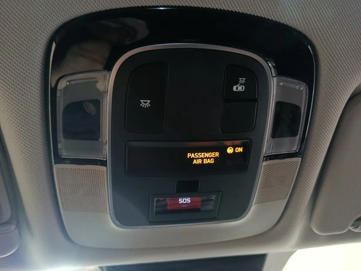 Vue intérieure du plafonnier du Hyundai Tucson gris foncé 2025, avec indicateur airbag passager et bouton SOS.
