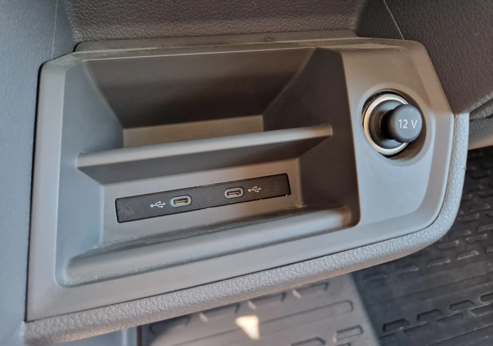 Gros plan intérieur sur la prise 12V et deux ports USB-C du Volkswagen Crafter blanc, version benne et coffre.