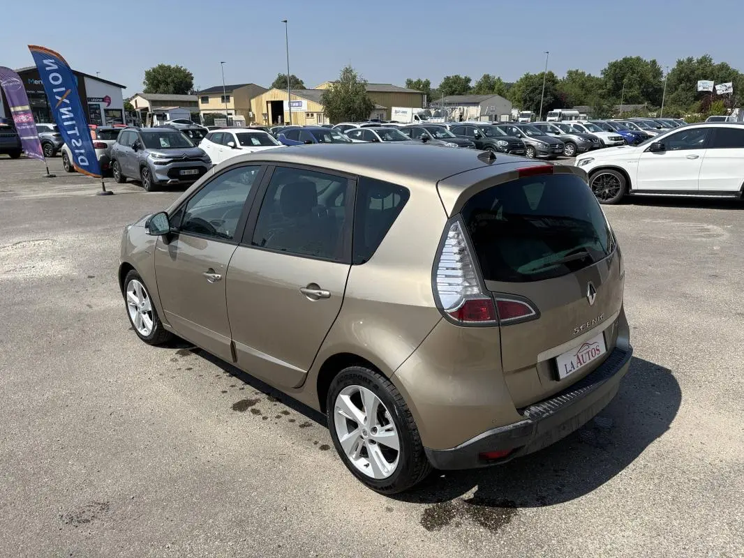 Renault Scénic III beige vue 3/4 arrière droit, vitres surteintées et jantes aluminium visibles en extérieur.