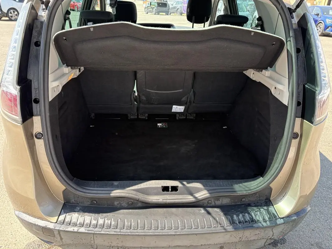 Vue arrière ouverte du coffre beige du Renault Scénic III 2015, montrant l'espace de chargement vide et la tablette cache-bagages.