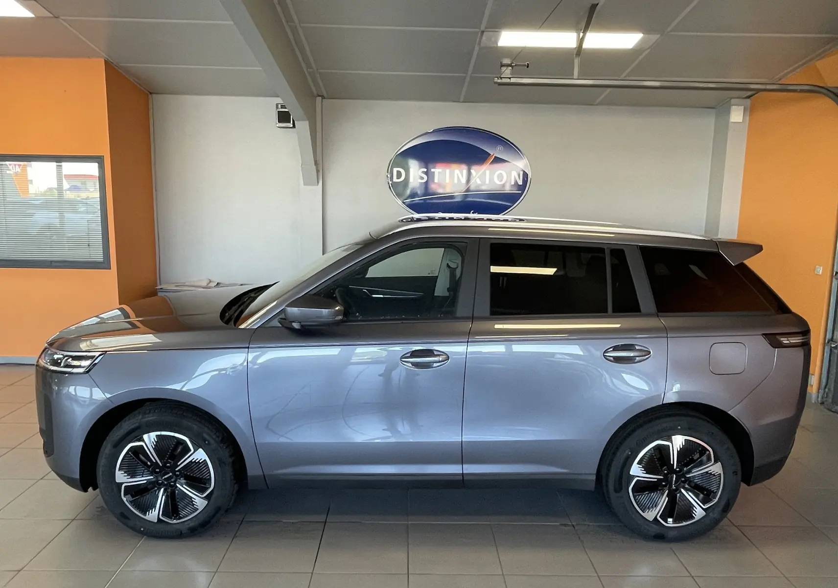 Vue de profil côté gauche du SUV JAECOO J5 2026 en gris Phantom Grey métallisé, avec jantes au design moderne et toit noir contrasté.
