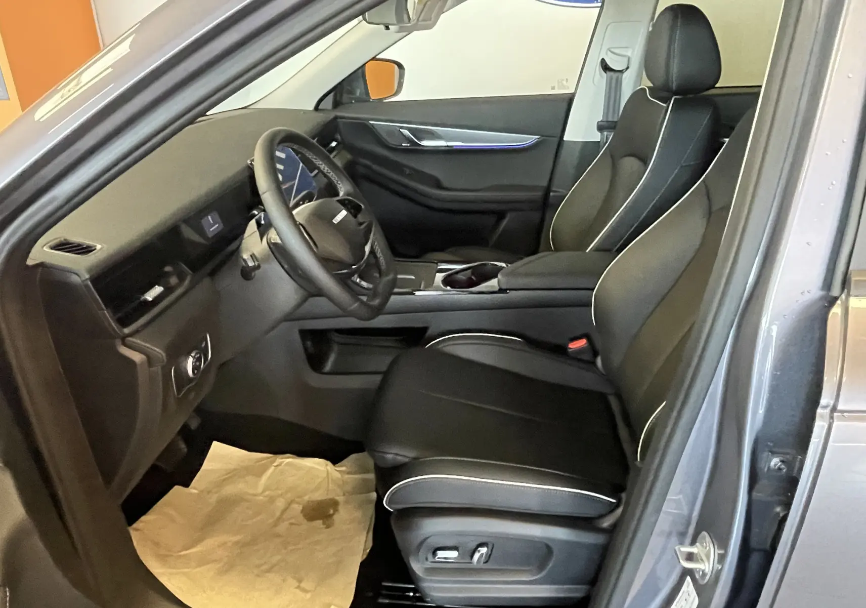 Vue intérieure côté conducteur du JAECOO J5 2026 en Phantom Grey Metal, sièges noirs cuir avec surpiqûres blanches.