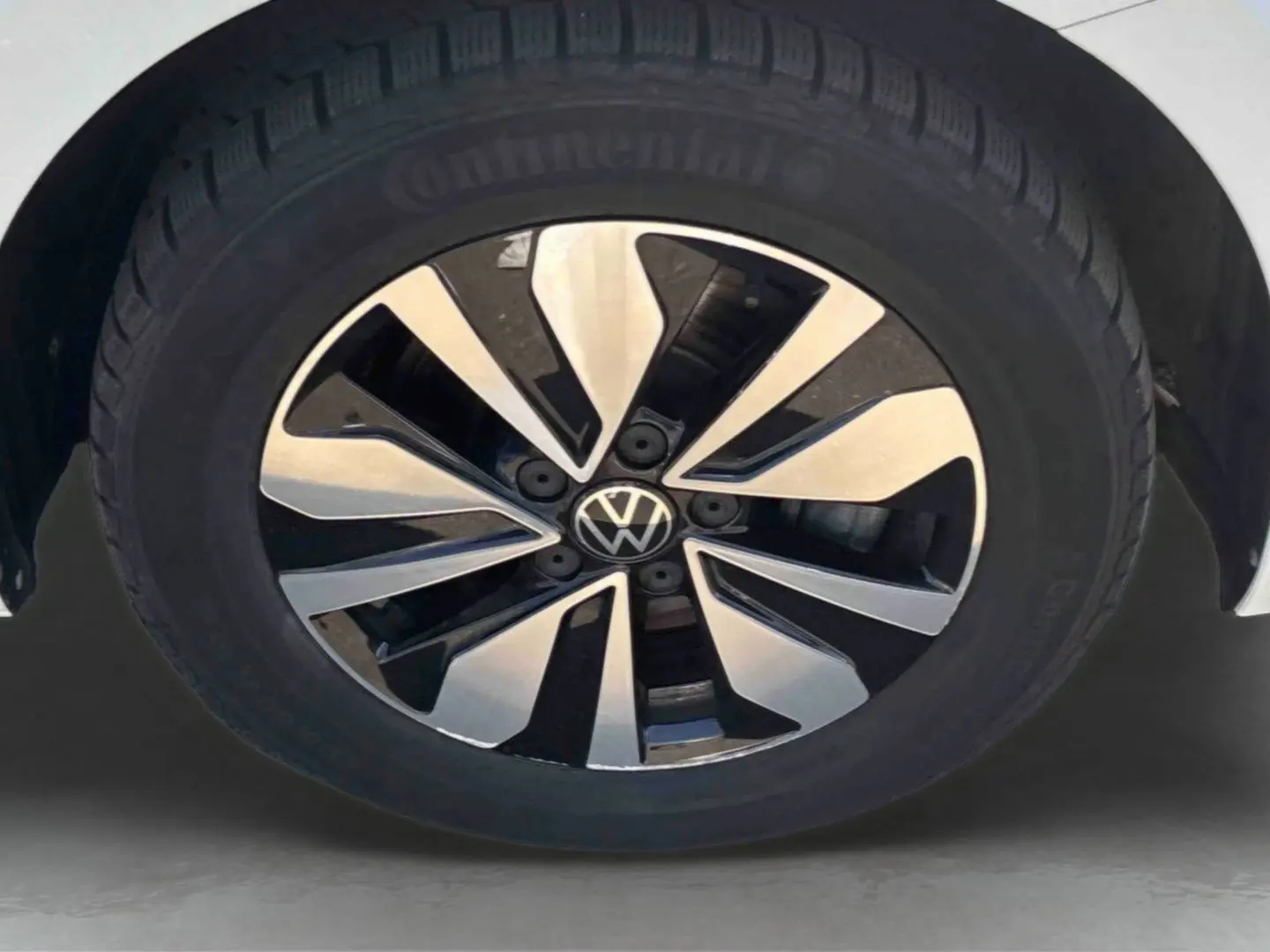 Gros plan sur la jante alliage bicolore du côté avant droit d’un Volkswagen Touran blanc.