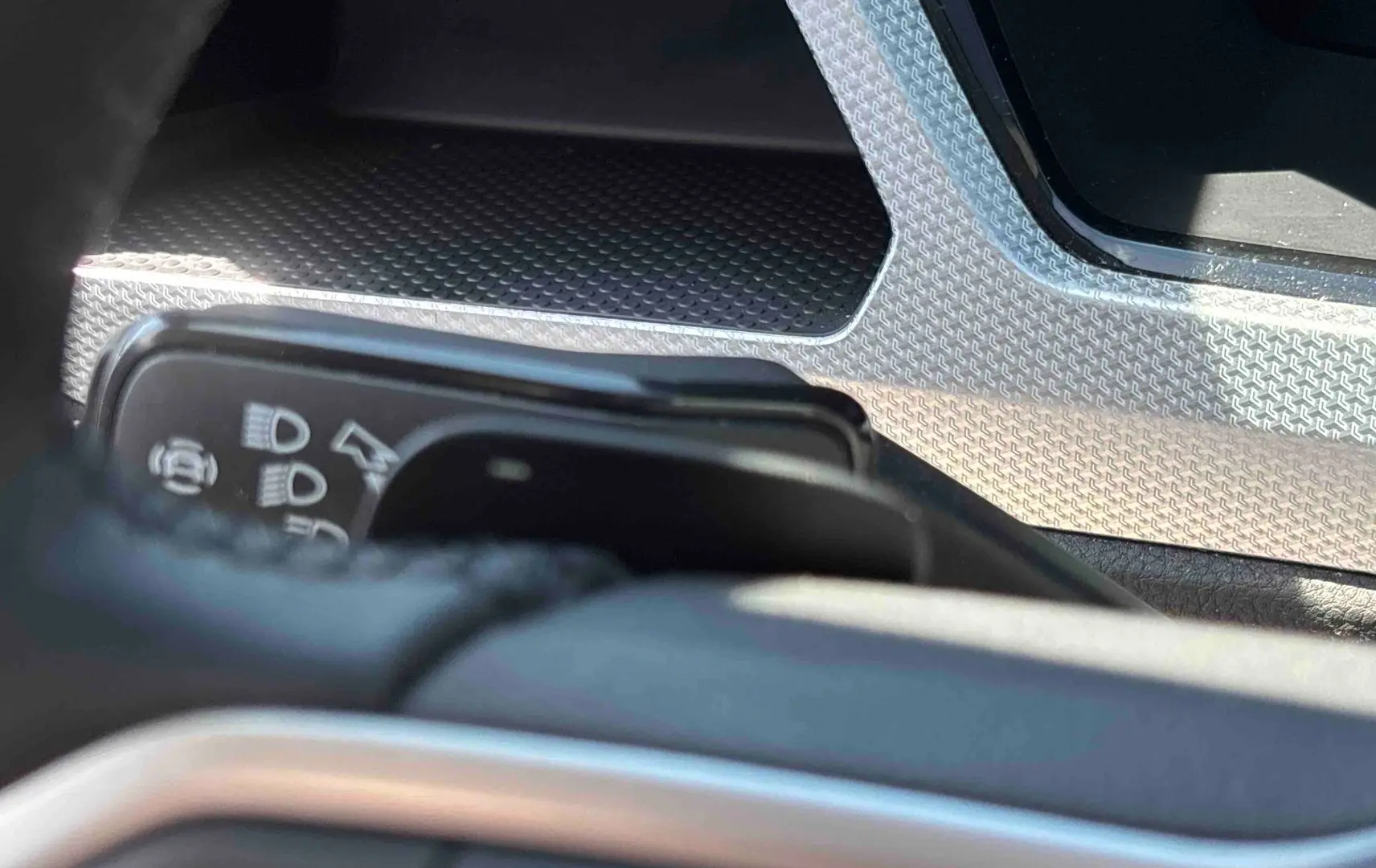 Détail intérieur du Volkswagen Touran 2025 montrant la commande des feux et un insert décoratif argenté.
