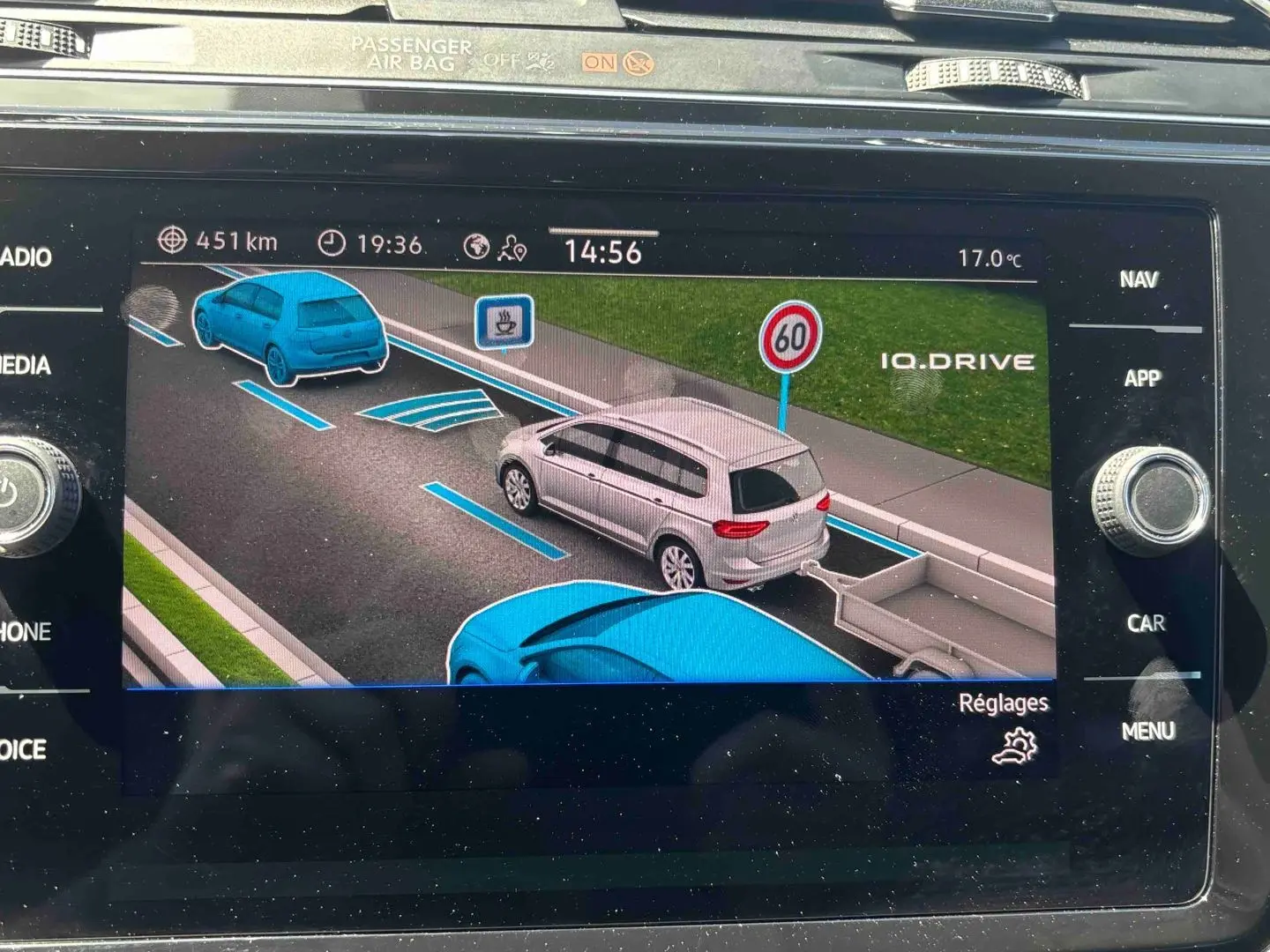 Affichage écran navigation montrant un Volkswagen Touran blanc vu de trois-quarts arrière avec remorque sur route à 60 km/h.