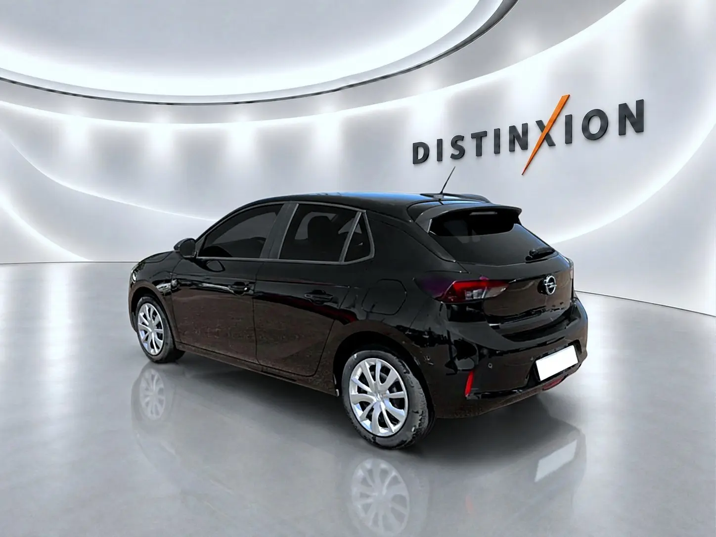 Opel Corsa 1.2 turbo noir vue 3/4 arrière droit dans un showroom lumineux avec logo Distinxion en arrière-plan.