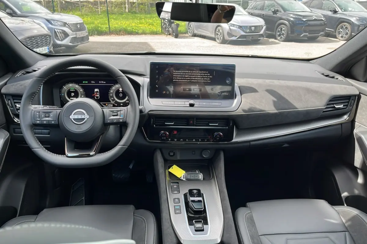 Vue intérieure avant du Nissan Qashqai E-POWER 205 N-DESIGN avec tableau de bord moderne et volant cuir multifonctions.