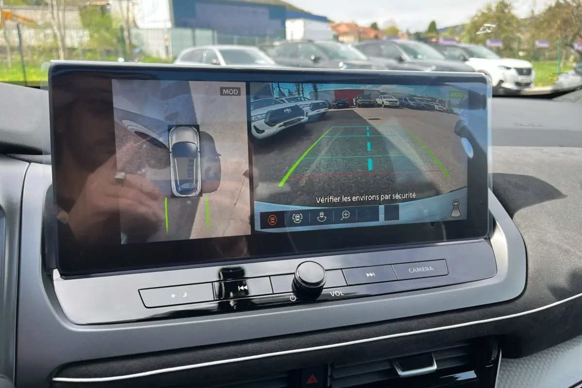 Écran central affichant la caméra 360° et la vue arrière du Nissan Qashqai blanc nacré avec toit noir.