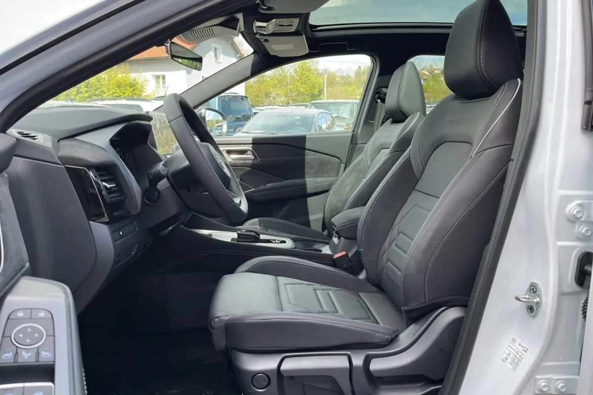 Vue intérieure côté conducteur du Nissan Qashqai E-POWER 205 N-Design avec sièges cuir alcantara noirs et toit panoramique visible.