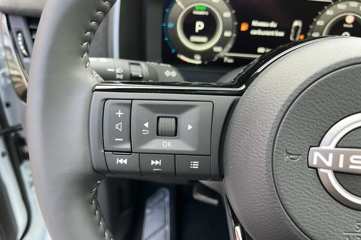Gros plan sur le volant cuir multifonctions gris du Nissan Qashqai E-POWER 2026 avec commandes intégrées.
