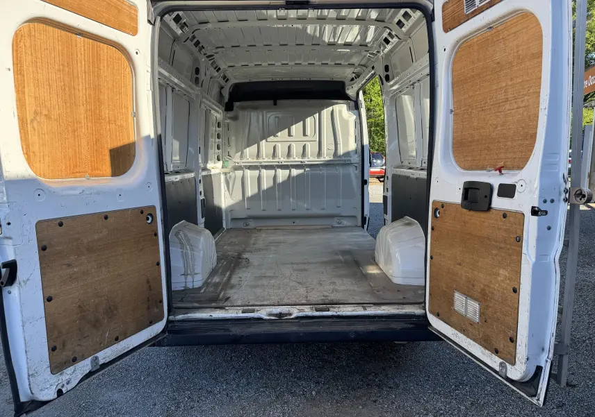 Vue arrière ouverte du Peugeot Boxer Fourgon blanc 2019, montrant l'intérieur vide avec panneaux en bois sur les portes.