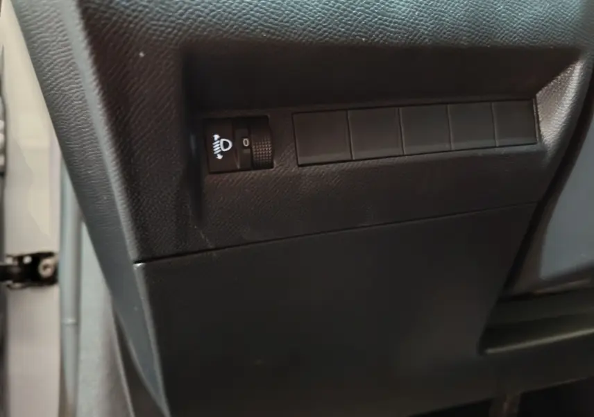 Détail du tableau de bord côté conducteur de la Peugeot 208 PureTech 100 S&S Allure gris clair, avec réglage des phares.