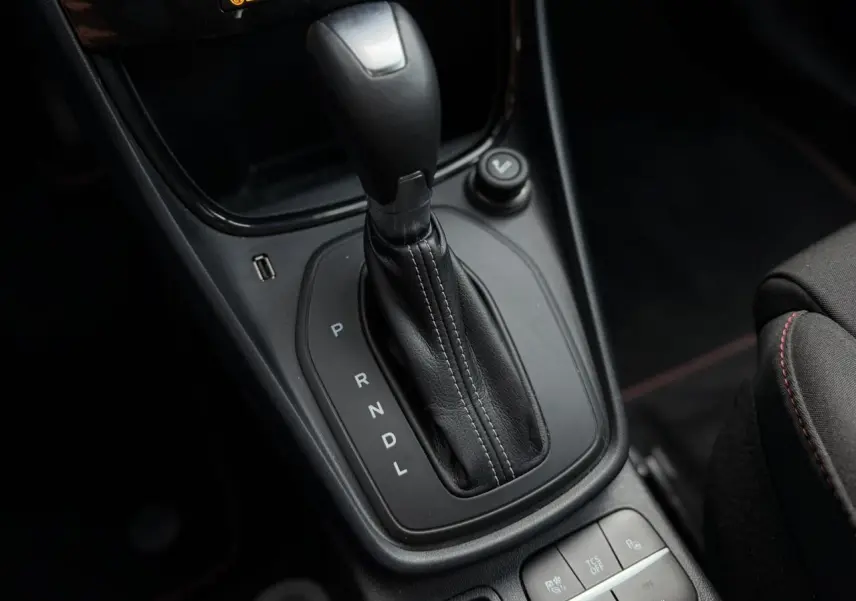 Gros plan sur la console centrale du Ford Puma gris magnétique, mettant en valeur le levier de vitesses automatique et les boutons de contrôle.