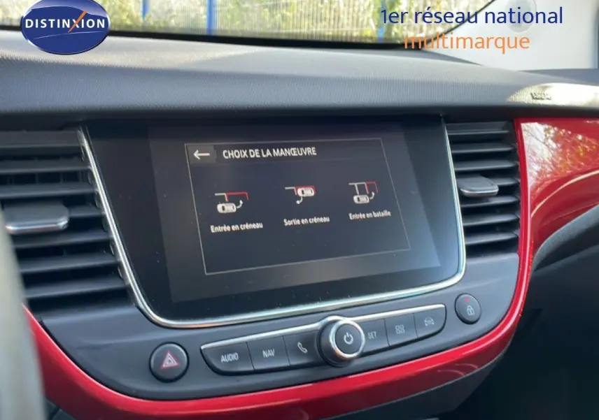 Vue intérieure centrée sur l’écran tactile du tableau de bord rouge brillant d’un Opel Crossland 2023.