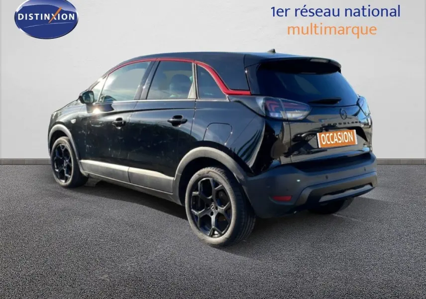 Opel Crossland noir Karbon Metal en 3/4 arrière droit, avec jantes noires et toit noir souligné de rouge.