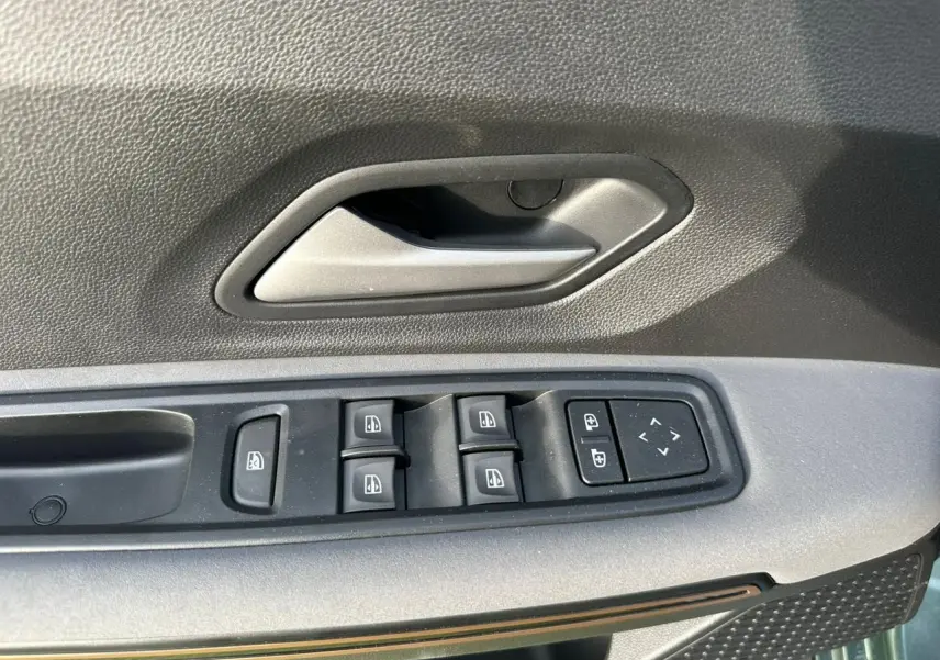 Gros plan sur la commande des vitres électriques côté conducteur de la Dacia Sandero III Stepway Vert Cèdre.