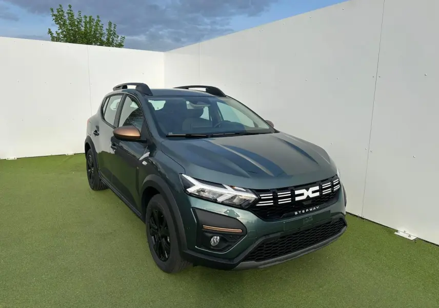 Dacia Sandero III Stepway vert cèdre en 3/4 avant droit avec calandre et rétroviseurs brun cuivré.