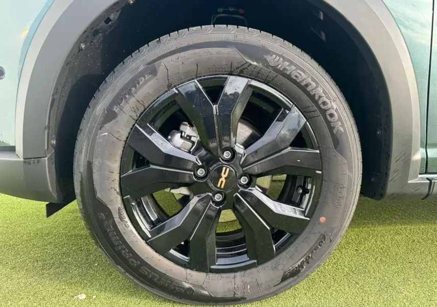 Gros plan sur la jante noire 16 pouces Mahalia du Dacia Sandero Stepway Vert Cèdre, avec partie basse de la carrosserie visible.