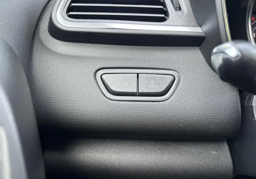 Gros plan sur les boutons ECO et arrêt du système start-stop du tableau de bord noir du Renault Kadjar gris foncé.