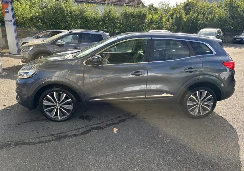 Renault Kadjar gris foncé vu de profil côté gauche, avec jantes alliage et vitres latérales surteintées.