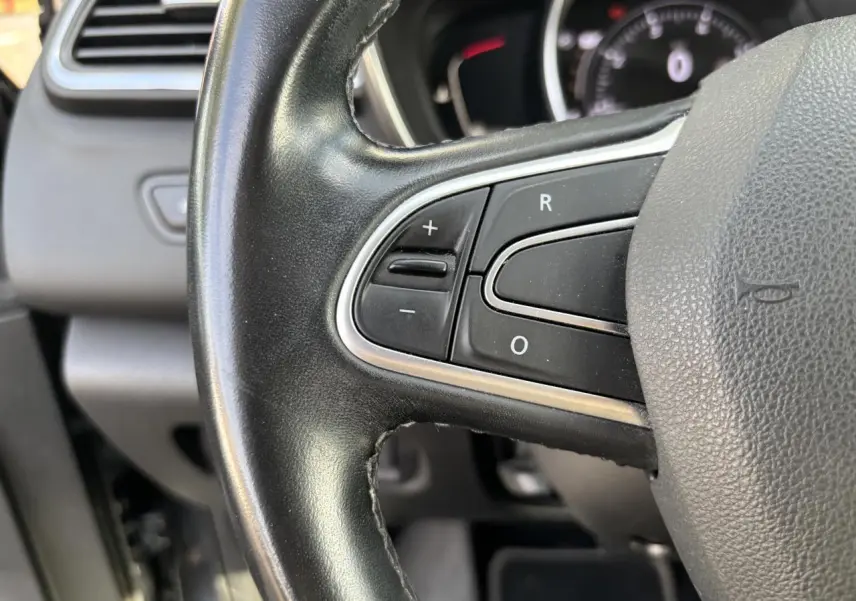 Gros plan sur le volant cuir noir du Renault Kadjar 2018 avec commandes intégrées et tableau de bord en arrière-plan.