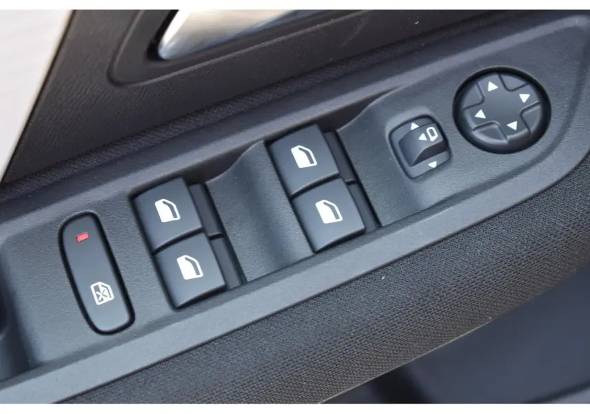 Gros plan sur les commandes de lève-vitres et réglages des rétroviseurs côté conducteur d'une Citroën C4 noire.